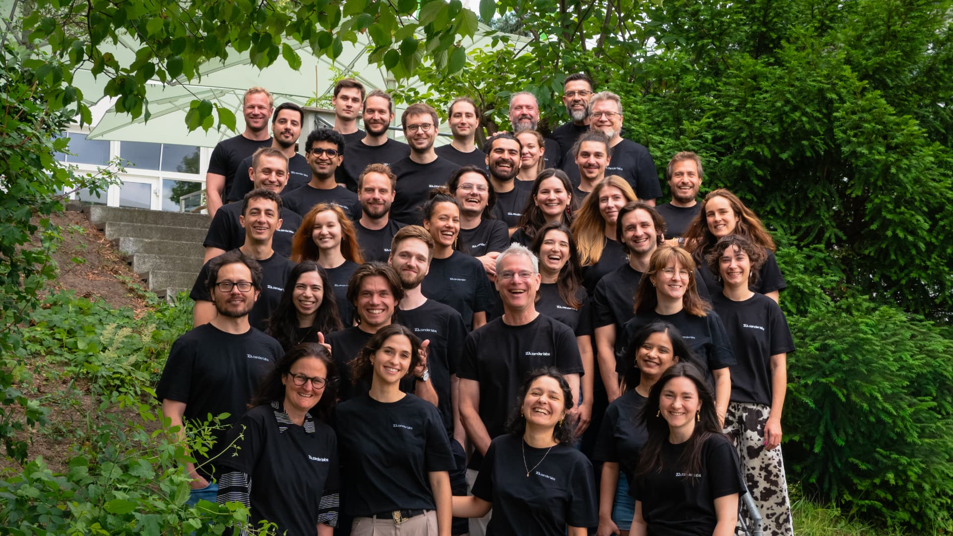 The Zander Labs team photographed together outdoors on concrete steps