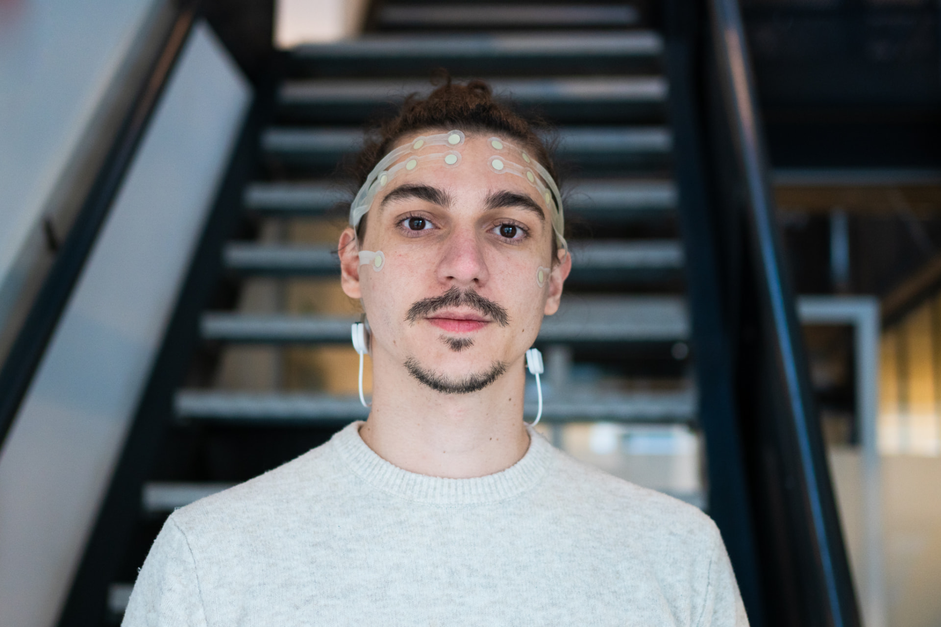 Research participant wearing the SAMANAI EEG sensor strip on a staircase